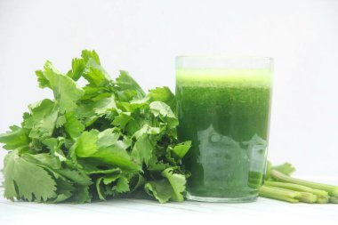 Kereviz suyu, kerevizden yapılmış sağlıklı yeşil içecek taze yeşil kereviz yapraklarıyla süslenmiş yeşil kereviz suyu.