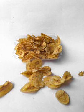 Beyaz arka plan izolasyonu serpiştirilmiş muz cipsi, musa paradisiaca muzlarından yapılmış muz cipsi.