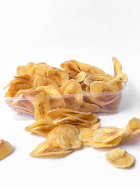 Beyaz arka plan izolasyonu serpiştirilmiş muz cipsi, musa paradisiaca muzlarından yapılmış muz cipsi.