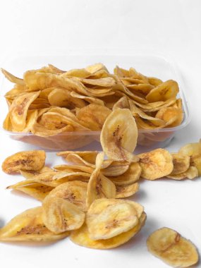 Beyaz arka plan izolasyonu serpiştirilmiş muz cipsi, musa paradisiaca muzlarından yapılmış muz cipsi.