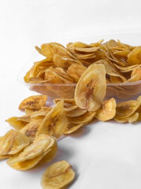 Beyaz arka plan izolasyonu serpiştirilmiş muz cipsi, musa paradisiaca muzlarından yapılmış muz cipsi.