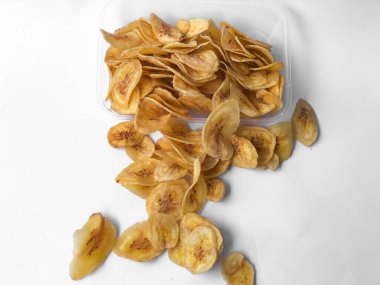 Beyaz arka plan izolasyonu serpiştirilmiş muz cipsi, musa paradisiaca muzlarından yapılmış muz cipsi.