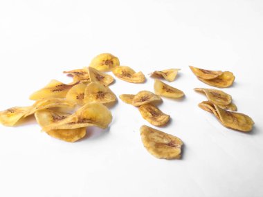 Beyaz arka plan izolasyonu serpiştirilmiş muz cipsi, musa paradisiaca muzlarından yapılmış muz cipsi.