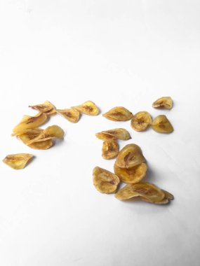 Beyaz arka plan izolasyonu serpiştirilmiş muz cipsi, musa paradisiaca muzlarından yapılmış muz cipsi.