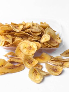 Beyaz arka plan izolasyonu serpiştirilmiş muz cipsi, musa paradisiaca muzlarından yapılmış muz cipsi.