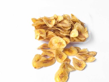 Beyaz arka plan izolasyonu serpiştirilmiş muz cipsi, musa paradisiaca muzlarından yapılmış muz cipsi.