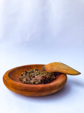 Terasili acı biber sosu ya da kabuklu karides ezmesi ya da Endonezyalıların genellikle otları ve baharatları öğütmek için kullandıkları geleneksel bir araç, beyaz arkaplanlı terasili kırmızı biber sosu.