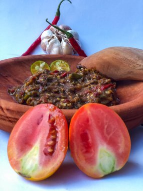 Terasili acı biber sosu ya da kabuklu karides ezmesi ya da Endonezyalıların genellikle otları ve baharatları öğütmek için kullandıkları geleneksel bir araç, beyaz arkaplanlı terasili kırmızı biber sosu.