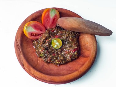 Terasili acı biber sosu ya da kabuklu karides ezmesi ya da Endonezyalıların genellikle otları ve baharatları öğütmek için kullandıkları geleneksel bir araç, beyaz arkaplanlı terasili kırmızı biber sosu.