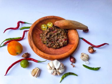 Terasili acı biber sosu ya da kabuklu karides ezmesi ya da Endonezyalıların genellikle otları ve baharatları öğütmek için kullandıkları geleneksel bir araç, beyaz arkaplanlı terasili kırmızı biber sosu.