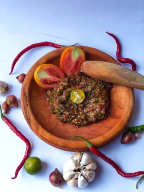 Terasili acı biber sosu ya da kabuklu karides ezmesi ya da Endonezyalıların genellikle otları ve baharatları öğütmek için kullandıkları geleneksel bir araç, beyaz arkaplanlı terasili kırmızı biber sosu.