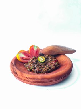 Terasili acı biber sosu ya da kabuklu karides ezmesi ya da Endonezyalıların genellikle otları ve baharatları öğütmek için kullandıkları geleneksel bir araç, beyaz arkaplanlı terasili kırmızı biber sosu.