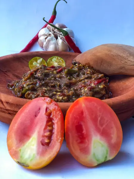 Terasili acı biber sosu ya da kabuklu karides ezmesi ya da Endonezyalıların genellikle otları ve baharatları öğütmek için kullandıkları geleneksel bir araç, beyaz arkaplanlı terasili kırmızı biber sosu.