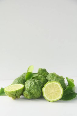 Beyaz bir kasede ve beyaz arka planda Kaffir limonu ya da bergamot meyvesi, kaffir limonu ya da narenciye suyu meyvesi.
