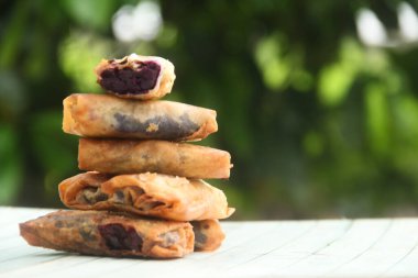 Yumurta rulosuyla kaplı mor patatesten yapılan yemekler, masada duran mor tatlı patatesten yapılan ev yapımı yemekler.
