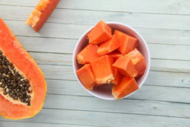 Papaya ya da Carica papayası dilimleri beyaz bir kasede, dilimlenmiş bir kase papaya servis edilmeye hazır.