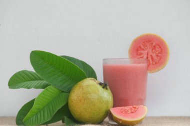 Guava ya da Psidium Guajava 'dan yapılmış meyve suyu olgun guava dilimleriyle süslenmiş ve beyaz bir arkaplanda izole edilmiş.