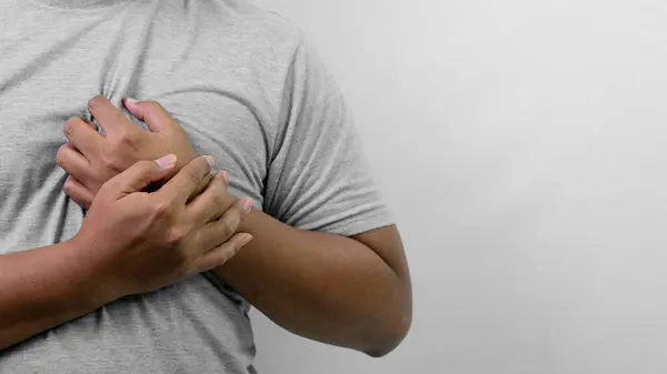 A young man felt short of breath while holding the left side of his chest with two hands and only half of his body was visible