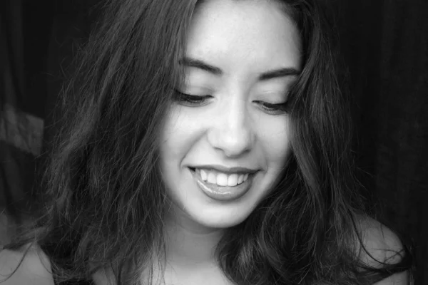 黒い背景に美しい笑顔を持つ美しい若い女性の黒と白の写真の肖像画 — ストック写真
