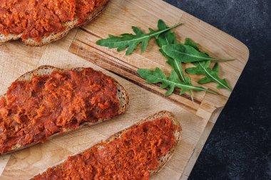 Ekmek dilimlerinden yapılmış tipik Malloran yemekleri et sobrasada ile ahşap kesme tahtasına yayılmış. Majorca 'nın geleneksel gastronomisi