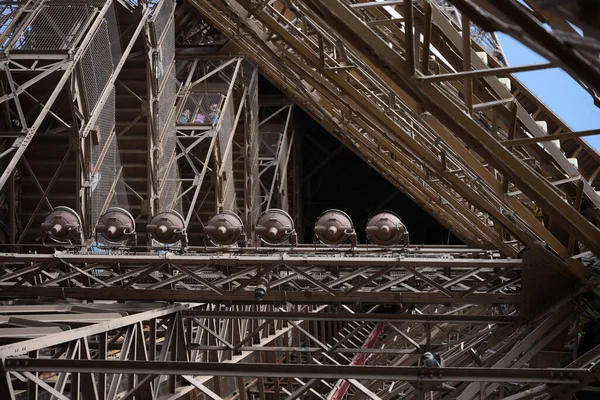Paris, France, July 26, 2023: Details of the metal structure of the Eiffel Tower with its many cross beams. An abstract and contrasting photo that highlights the delicate and complex architecture of the tower. Light and natural colors.