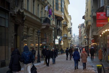 Budapeşte, Macaristan - 30 Kasım 2023: Yılbaşı pazarı ve alışveriş caddesinde karlı bir sabah, şenlik dekorasyonu ve arka planda Aziz Stephen Bazilikası