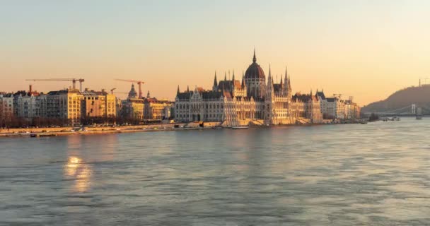 匈牙利布达佩斯 2024年1月10日 日落时的国会大楼 在多瑙河上漂浮的公共汽车 工作起重机的背景 时间间隔 — 图库视频影像