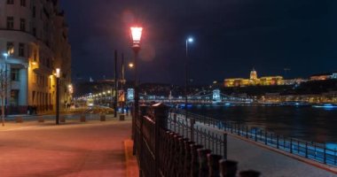 Budapeşte, Macaristan - 26 Ocak 2024: Gece Şehri simgesi. Arka planda Buda kalesi var. Tramvaylar orta sahada hareket ediyor. Zaman aşımı.