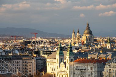 Budapeşte, Macaristan: 20 Şubat 2024: Şehir manzarası. St. Stephen Bazilika binası ve arka planda dönme dolap..