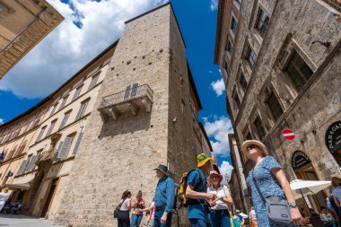 Siena, İtalya - 01 Haziran 2024: Siena 'nın güzel caddesinde bir grup turist. Aşağıdan yukarıya görünüm.