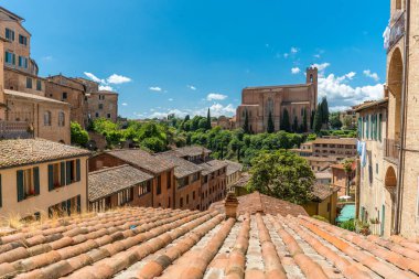 Siena, İtalya - 01 Haziran 2024: San Domenico Kilisesi ve konut binaları. Güneşli bir gün, açık bir gökyüzü.