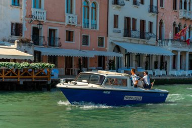 Venice, Italy - June 04, 2024: Police boat at Venice canal. Officers sitting on the edge of the boat. Sunny day in summer. clipart