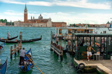 Venedik, İtalya - 4 Haziran 2024: Gondolas Iconic San Giorgio Maggiore Bazilikası 'nın yanında yüzüyor. Buhar sağda duruyor..