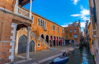 Venedik, İtalya - 3 Haziran 2024: Köprüden renkli ve sakin bir kanala bakın. Güneşli bir gün, açık bir gökyüzü.