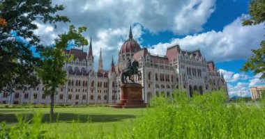 Budapeşte, Macaristan - 16 Haziran 2024: Sıcak bir günde parlamento binası. Zaman aşımı, kayma geçiş. Güneşli bir gün, orta bulutlu bir gökyüzü.