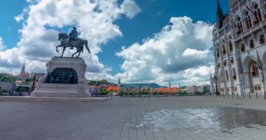 Budapeşte, Macaristan - 16 Haziran 2024: Sıcak bir günde parlamento binası yakınlarındaki su sisi soğutma sistemi. İnsanlar sakinleşmeye geliyor. Zaman aşımı, kayma geçiş. Güneşli bir gün, orta bulutlu bir gökyüzü.