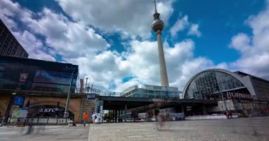 Berlin, Almanya - 23 Haziran 2024: Alexanderplatz tren istasyonu. Arka planda televizyon kulesi var. Zaman atlaması. Güneşli bir gün, orta bulutlu bir gökyüzü.