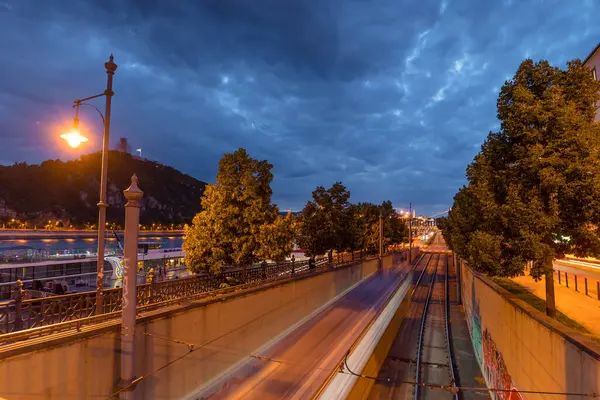 stock image Budapest, Hungary: July 03, 2024: Tram lines at night, view from Fovam ter. Long exposure shot.