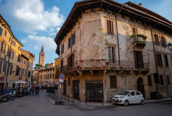 Verona, İtalya - Haziran 06, 2024: Tarihi Verona Caddesi 'nde gün batımı. Parçalanmış bir cephe sessiz bir sokakta modern dünyayla buluşuyor..