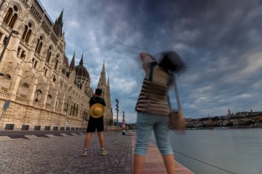 Budapest, Hungary - July 08, 2024: Cityscape view to Buda and Pest from Pest side. Buda castle and Fisherman bastion on the right. Tourists taking pictures with the parliament in the background. clipart