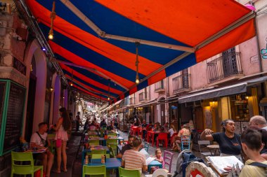 Catania, İtalya - 18 Mayıs 2024: Restoranları olan renkli ara sokak.