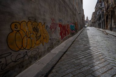Catania, İtalya - 18 Mayıs 2024: Duvarında grafiti olan boş cadde. Arka planda San Nicolo Kilisesi var..