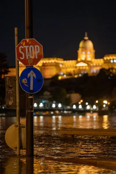 stock image Budapest, Hungary - September 17, 2024: A Man Riding an Electric Scooter in Budapest with the Flooded Danube River in the Background, Highlighting the City Flooding Challenges