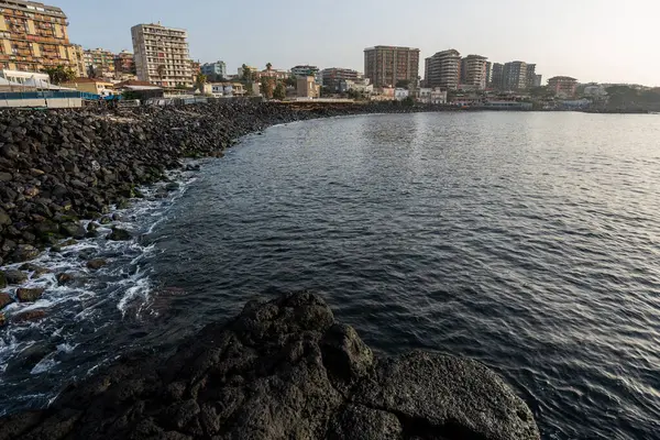 Catania, İtalya - 20 Mayıs 2024: Katanya 'nın Rocky kıyıları: Kentsel ufuk çizgisi ve sakin suların bir karışımı.