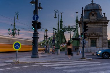 Budapeşte, Macaristan - 26 Temmuz 2024: Yerel ve Turistler Budapeşte 'nin Özgürlük Köprüsü' nde güneşli bir günün tadını çıkarıyorlar. Zaman ayarlı, kaydırmalı geçiş.