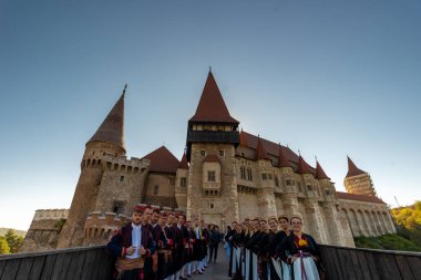 Hunedoara, Romania - October 20, 2024: Corvin castle with people in traditional clothes in the foreground. clipart