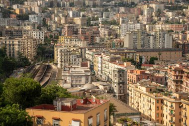 Napoli, İtalya - 27 Mayıs 2024: Napoli 'nin yukarıdan görünüşü, yemyeşil yeşilliklerle çerçevelenmiş, renkli binalarıyla şehir manzarasını bir anlığına sunuyor.