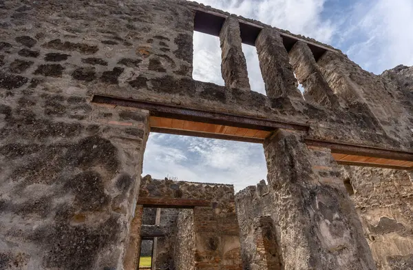 Pompei, İtalya - 25 Mayıs 2024: Pompei 'deki bir evin yıkıntılarını tutan çerçeve, antik kentin kırılgan yapılarını korumak için devam eden çabaları yansıtıyor.