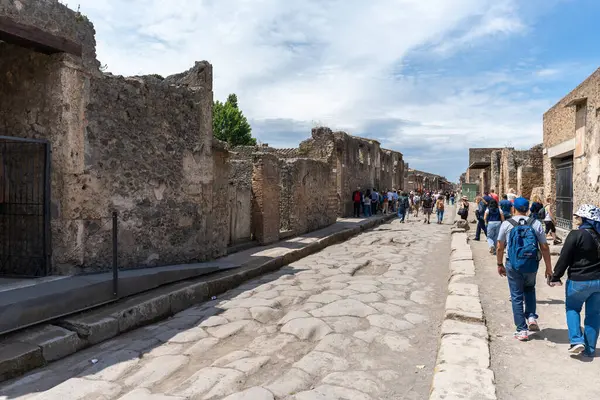 Pompei, İtalya - 25 Mayıs 2024: Pompeii 'de ana cadde boyunca yürüyen turistler.