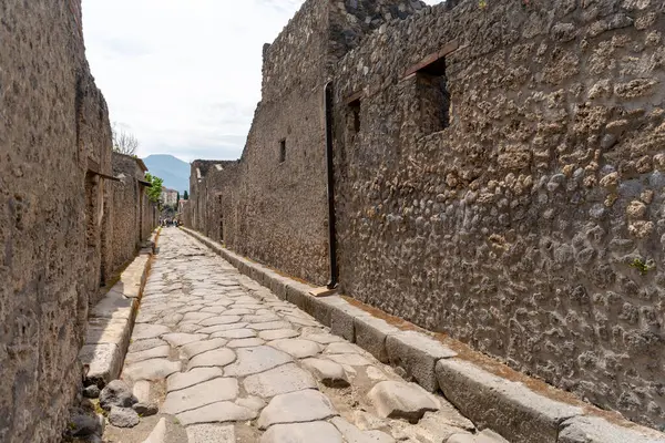 Pompei, İtalya - 25 Mayıs 2024: İtalya 'nın en ünlü arkeolojik alanlarından biri olan Pompeii' de bir sokak, antik Roma yaşamına bir bakış sunuyor. Sokaklar genellikle büyük taşlarla kaplıdır..